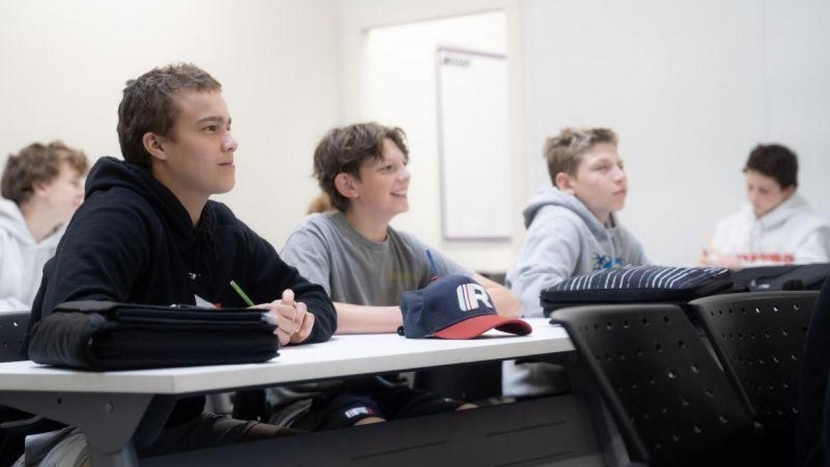Image of three students sitting in a row in a classroom at RINK Hockey Academy